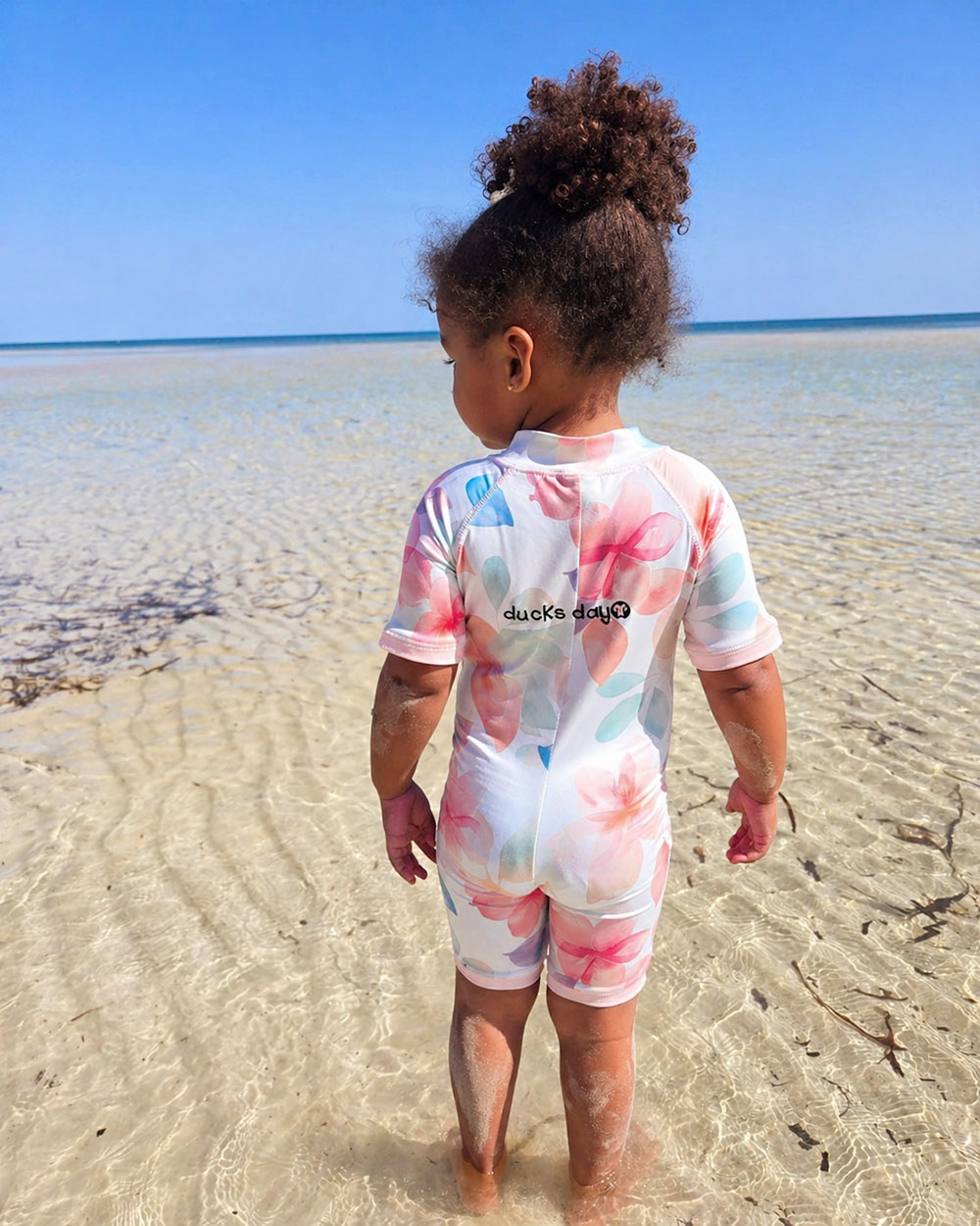 Niemowlę w odzieży UV nad wodą podczas wakacji